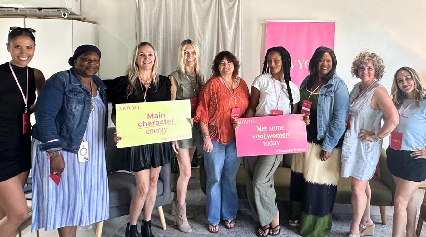 Women at a Movyo community event holding colorful signs